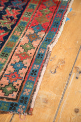 Secured selvedge and geometric cross-section motifs on the vintage Caucasian rug's border.