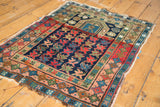 Vintage Caucasian prayer rug, geometric plant motifs, central mehrab, and abrashed indigo field.