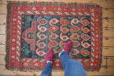 Indigo blue abrashed field with oversized botehs, floating mehrab, and cochineal red star burst border.