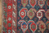Antique Caucasian rug's indigo abrashed field with colorful oversized botehs and barber pole border.