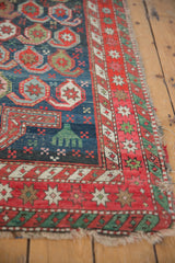 Tattered side of antique Caucasian rug, highlighting red star burst border and sacred green minor border.