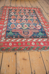 Hard tatter to the side of a Caucasian rug with an emerald green and red geometric border.