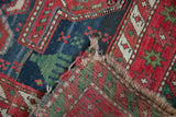 Antique Caucasian rug's folded corner, revealing hand-knotted weave, dense pile, and worn fringe.