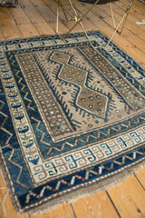 Geometric medallion and pearl fills on vintage Caucasian rug in cobalt blue and beige.