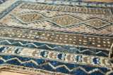 Interconnected geometric patterns in cobalt blue, charcoal, and silver on a vintage Caucasian rug.