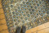 Geometric splayed floral motifs and intricate border designs on an antique Caucasian rug.