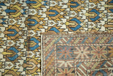 Folded edge of antique Caucasian rug, revealing geometric pile and hand-knotted foundation.