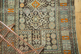 Detailed geometric pinwheel patterns and varied colors on an antique Caucasian rug.