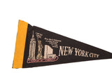 Close-up of vintage black felt pennant, yellow trim, and beige New York City graphics.