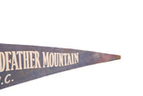 Vintage felt pennant tip with faded blue and reddish hues, partially showing 'MOUNTAIN' text.