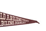 Brown felt pennant displaying white 'Old Abilene Town Abilene, Kansas' text, with creases.
