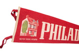 Illustrated Betsy Ross House and 'Philadelphia' text on vintage red felt pennant.