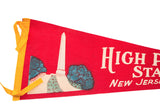 High Point State Park vintage red felt pennant showing white monument, blue bushes, yellow border.