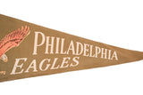Ivory 'DELPHIA EAGLES' on vintage tan felt flag with peach wing, showing soft creases.