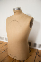 Back of vintage tan mannequin bust with Cavanaugh script and fabric texture.