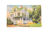 Vintage postcard of Belvedere Manor: white house, green roof, yellow Adirondack chairs.