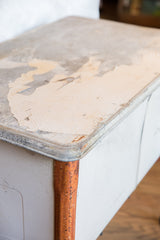 Rustic galvanized wash tub corner, displaying peeling white paint and textured rust.