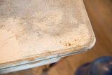 Detail of vintage galvanized wash tub's original lid, showing peeling white paint and rust.