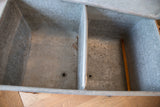 One galvanized metal wash tub basin interior with drain, textured surface, and rustic patina.