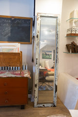 Heavily chipped white paint frame on a vintage reclaimed copper door mirror.