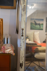 Distressed white paint and vintage handle on the reclaimed copper door mirror frame.