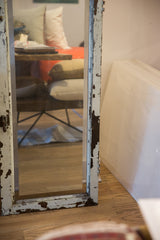 Heavily chipped white paint revealing distressed copper on the mirror's lower frame.