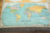 Antique Nystrom world map in hemispheres with creased canvas and discolored lower edge.
