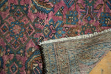 Persian Lilihan rug detail, fuchsia herati motif pile, cream fringe, and striped foundation.