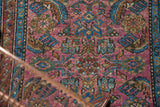 Intricate herati motif in plum fuchsia, sky blue, and wine red on vintage Lilihan rug.