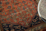 Detail of antique Malayer rug with refined Herati motif on terra cotta field and indigo border.