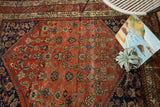 Refined Malayer rug corner, showcasing unique Herati pattern in terra cotta and indigo.