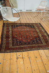 Antique Malayer rug fringed end, displaying brick red field and intricate beige border.