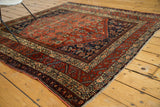 Corner of an antique Malayer rug, showing intricate Herati motif in terra cotta and indigo.