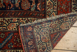 Antique Malayer rug's folded corner, revealing hand-knotted foundation, fringe, and herati motif.