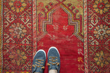 Cherry red field of the Mudjur prayer rug with beige floral cross-section border.