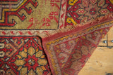 Tattered fringe, woven red and saffron foundation, and floral pattern on a vintage Mudjur rug.