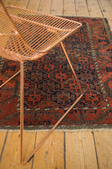 Antique Belouch rug's repeating lattice trellis, gul motifs, and pearl minor border in rust and brown.