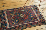 Corner detail of the antique Jaff Kurd mat with partially secure sides and indigo gul motifs.