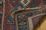 Antique Jaff Kurd rug corner detailing geometric border and tattered fringe.