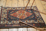 Angled view of a collector's antique Persian bag face showing its expressive medallion and time-softened colors.