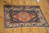 Antique Persian bag face rug mat shown in context, displaying its bold floral medallion and rich colors.