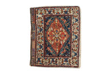 Antique West Persian bag face with a large brick red and navy floral medallion and expressive vinery.
