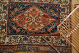 Detail of a collector's antique Persian bag face showing the brick red floral medallion and navy vinery.