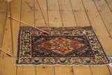 An antique Persian bag face rug, highlighting its warm colors and compact size.
