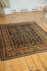 Corner view of vintage Malayer rug, displaying intricate herati motif with animals to fringed end.