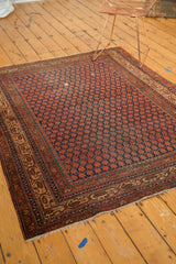 Antique Malayer rug corner: rust boteh field, dark indigo, Mir Serbend border, and fringe.