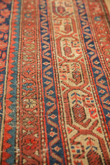 Antique Malayer rug detail: Visible knot heads and textured geometric patterns in rust, indigo, and ivory.