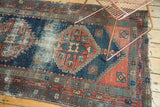 Primitive rectilinear motifs and indigo blue with faded brick red tones on an antique Heriz rug.