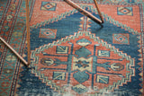 Antique Heriz rug with primitive rectilinear design and stepped medallion contour, faded red, indigo blue.