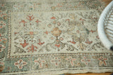 Vintage Oushak rug's worn pile, exposed foundation, and muted ivory, peach floral cross-sections.